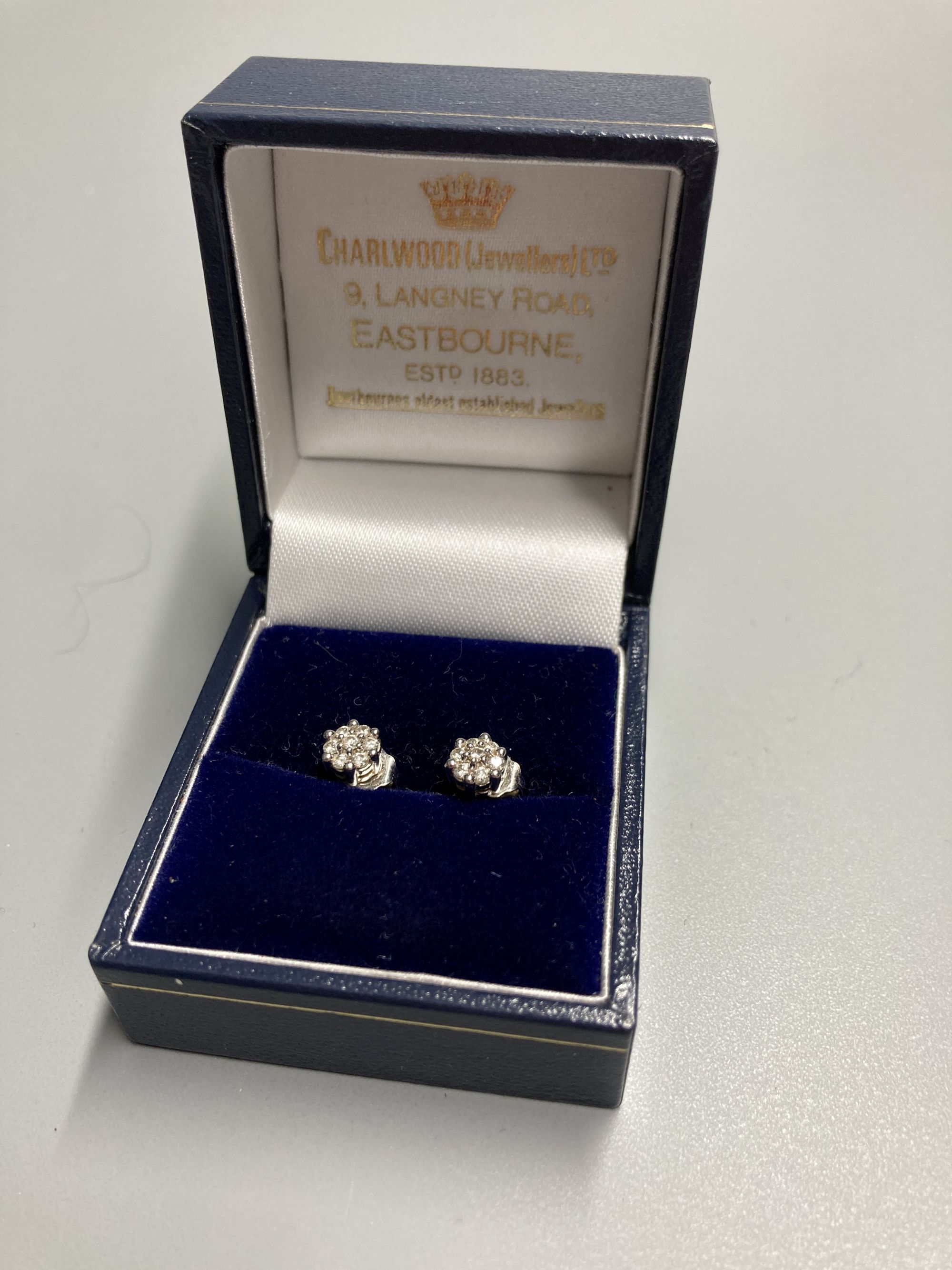 A pair of modern white metal (stamped 750) and small seven stone diamond cluster ear studs, 5mm, gross 1.6 grams.